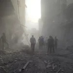 Warga Palestina berjalan di antara puing-puing setelah serangan Israel di halaman Rumah Sakit Kamal Adwan di Beit Lahiya, Gaza, pada 25 Desember 2024 [Khalil Ramzi Alkahlut/Anadolu]