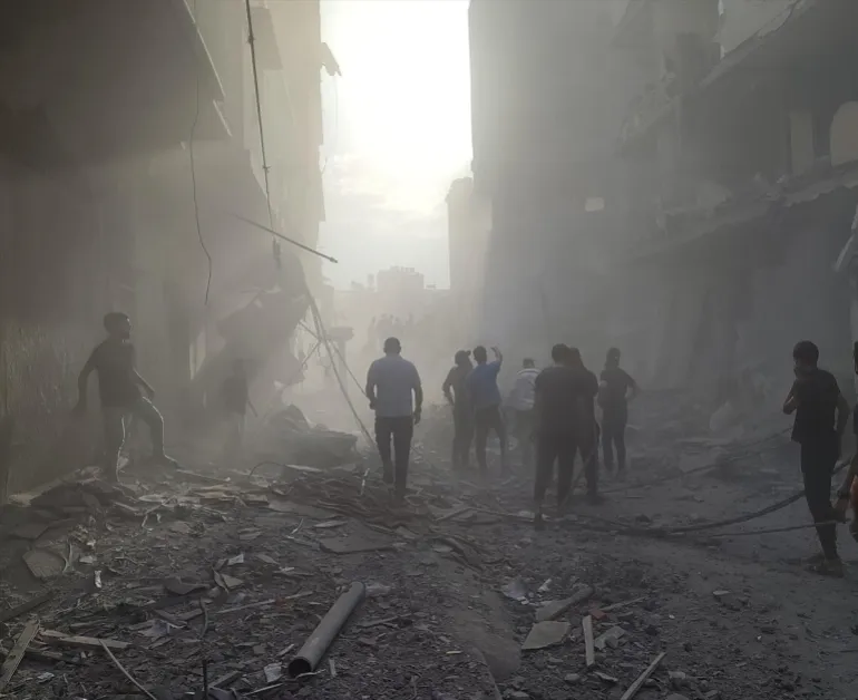 Warga Palestina berjalan di antara puing-puing setelah serangan Israel di halaman Rumah Sakit Kamal Adwan di Beit Lahiya, Gaza, pada 25 Desember 2024 [Khalil Ramzi Alkahlut/Anadolu]